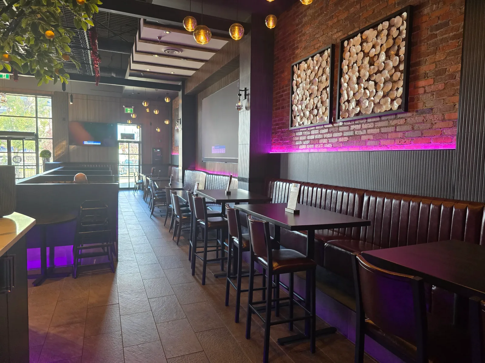 Booth dining room with exposed brick and warm lighting at THE PIZZA SPOT – Italian restaurant seating at our West Edmonton Mall location